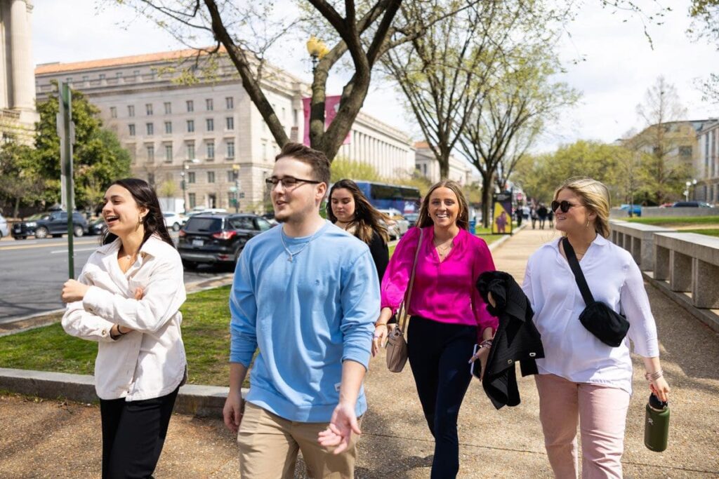 Four students walk down the street in Washington, D.C. on a networking trip.