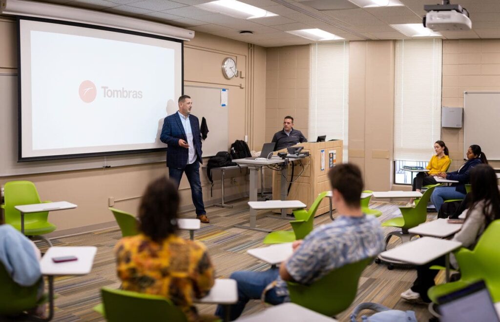 Alumni and guest speaker from Tombras agency presents to a class.