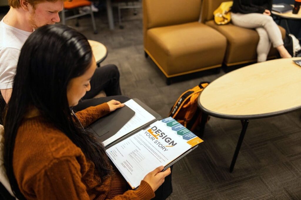 A student looks at a document that says "Design Your Story"