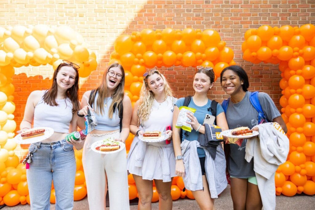 Five students stand in front of balloons that spell out CCI.